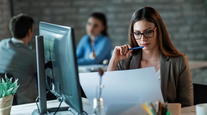 woman reviewing document in front of computer